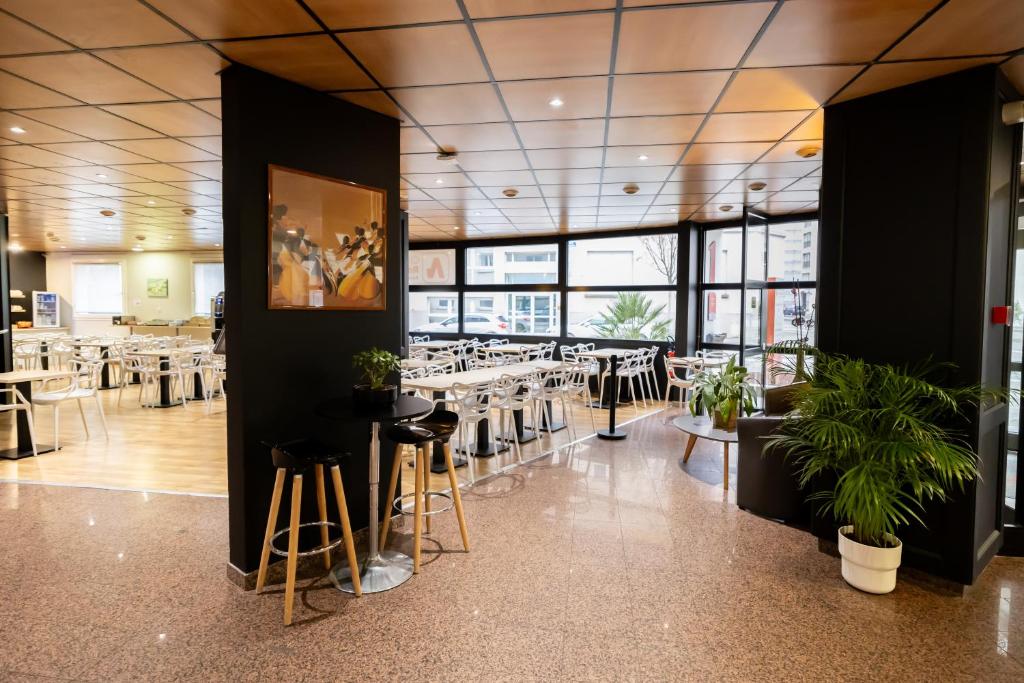 - une salle à manger avec des tables, des chaises et des fenêtres dans l'établissement City Résidence Strasbourg Centre, à Strasbourg