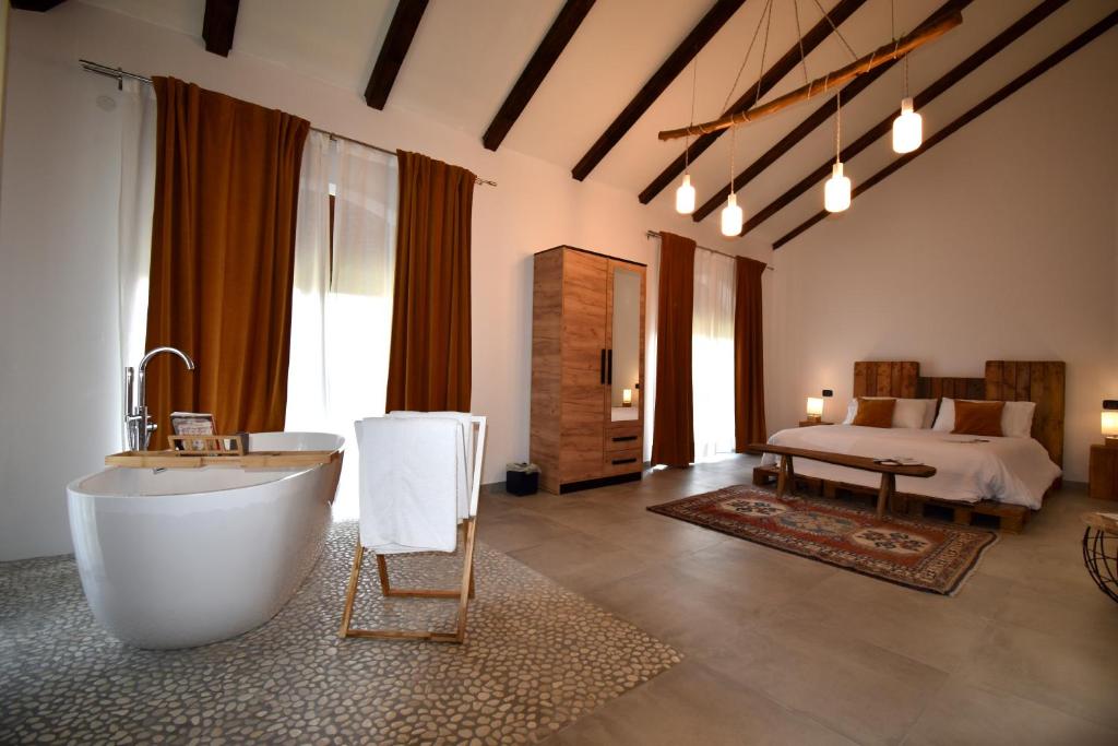 a large bathroom with a tub and a bed at Cascina Tre Botti in Agliano Terme