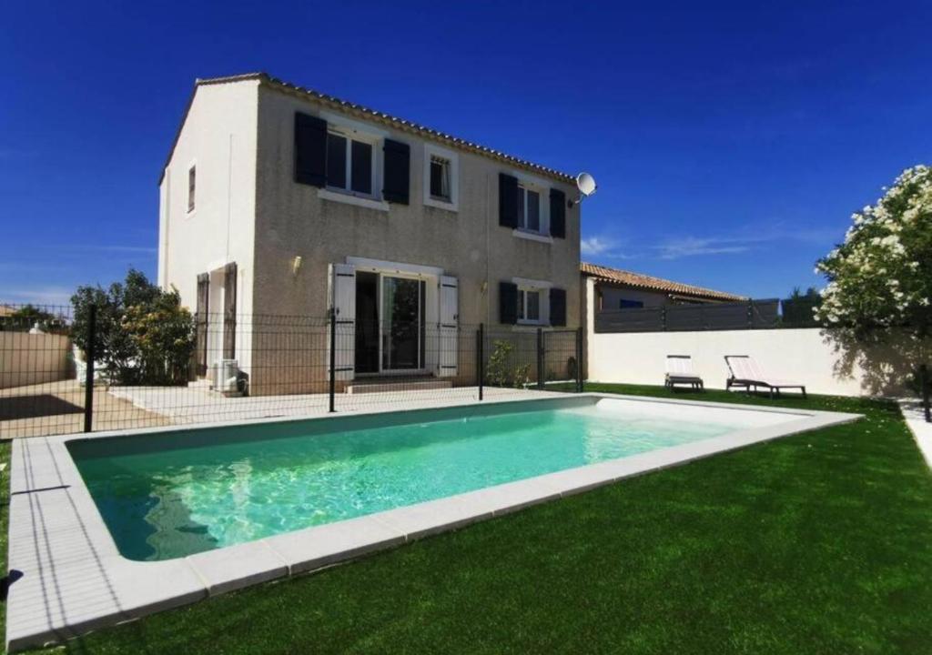 une villa avec une piscine en face d'une maison dans l'établissement Villa avec Piscine • Plage 15’, à Béziers