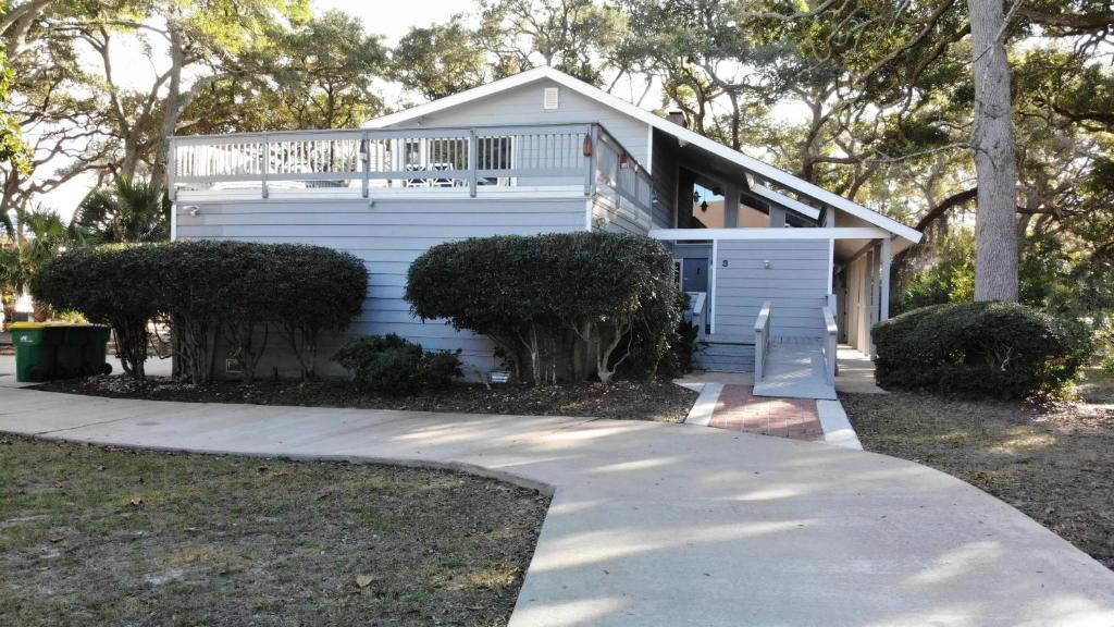 uma casa branca com um alpendre e uma entrada em OCEAN RETREAT home em Jekyll Island