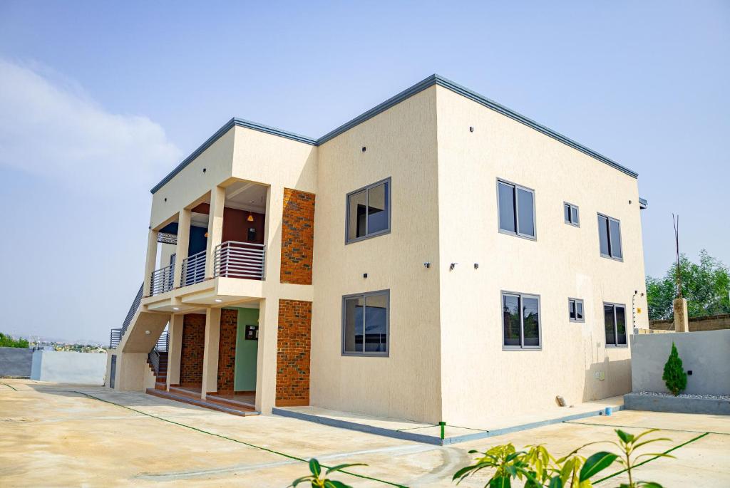 a large white house with a lot of windows at CMP APARTMENTS in Kasoa