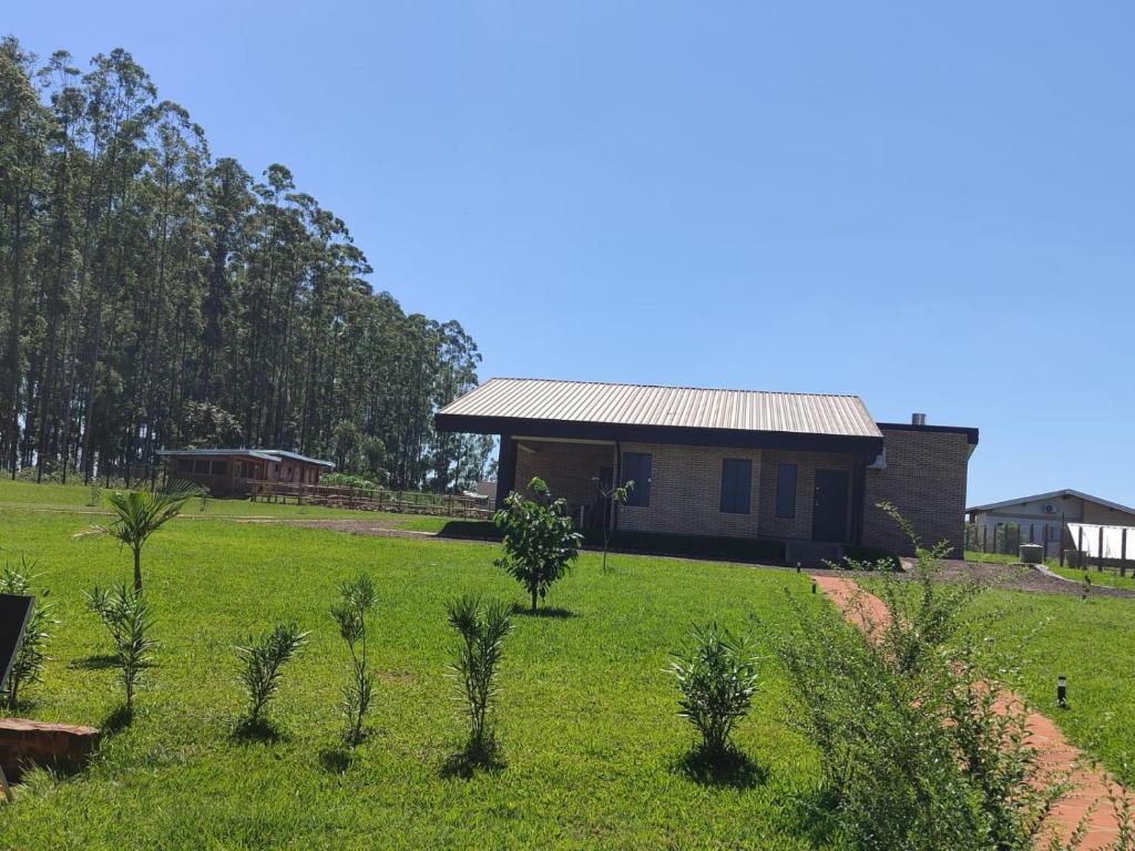 Hohenau的住宿－Modernes Ferienhaus in Paraguay, Hohenau mit Reitanlage und Beachvolleyball，绿色田野中间的房子