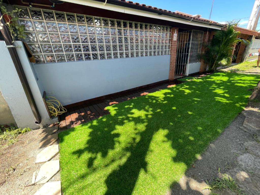 イタニャエンにあるCasa em Itanhaém Pé na Areia ! A 100 metros do marの隣の芝生の影