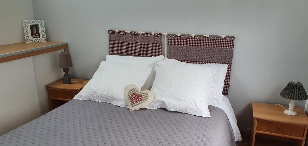 una camera da letto con un letto con cuscini bianchi di La canadienne a Évreux