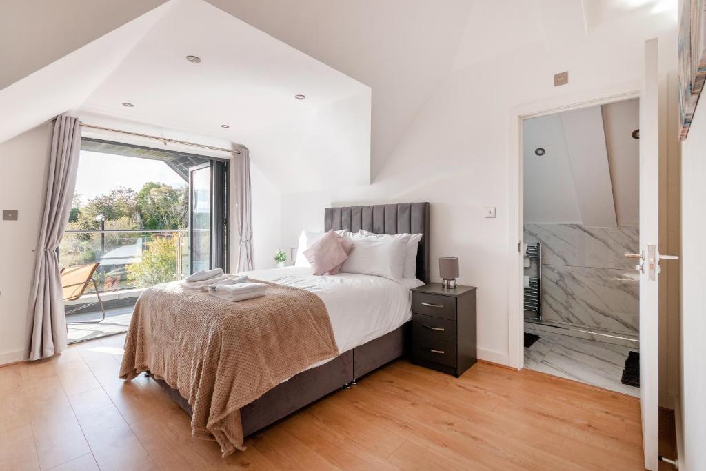 a white bedroom with a bed and a large window at Refined Living: Three Bedrooms Flat in Coulsdon CR5 in Coulsdon