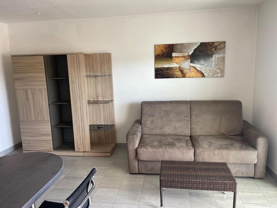 un salon avec un canapé et une table dans l'établissement Location Studio Meublé Terrasse, à Porto-Vecchio