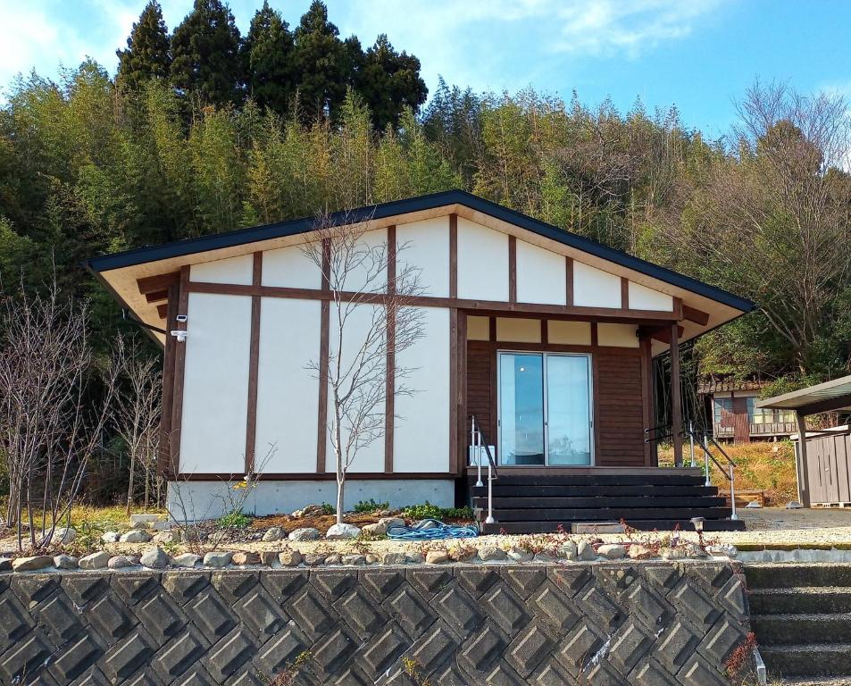 una pequeña casa al lado de una colina en 能登島ゲストハウスうたたね, en Nanao