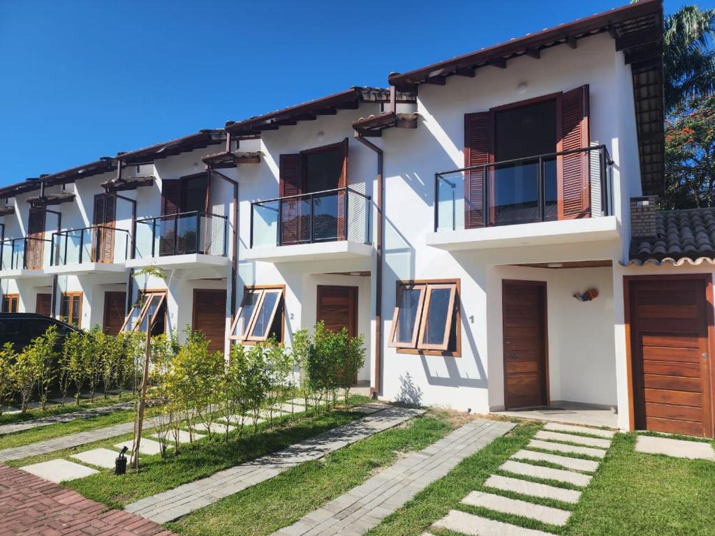a white apartment building with balconies and a yard at Casa Maritaca in Paraty