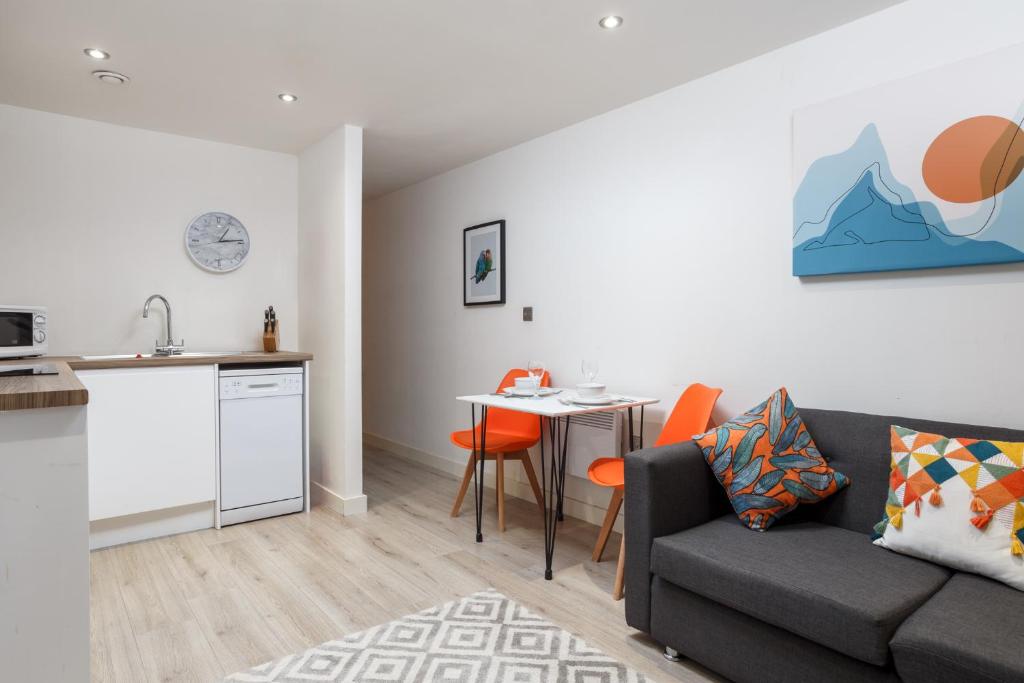 sala de estar con sofá, mesa y cocina en One-Bedroom Apartment in Conditioning House, en Bradford