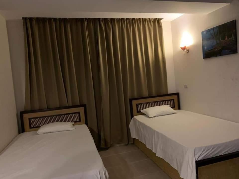 dos camas sentadas una al lado de la otra en una habitación en شاليه داخل ميراج اكوا بارك en Hurghada