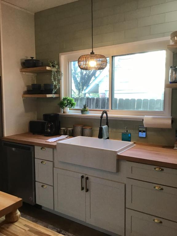 a kitchen with a white sink and a window at Big Red Cactus - Austin Accommodations in Austin