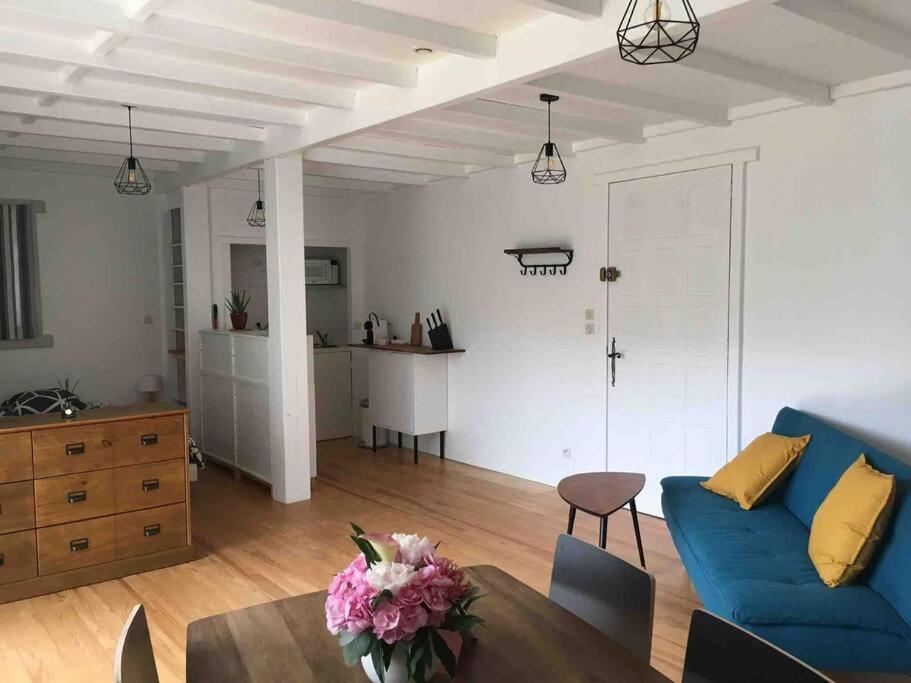 een woonkamer met een blauwe bank en een tafel bij Studio independant dans maison basque in Bassussarry