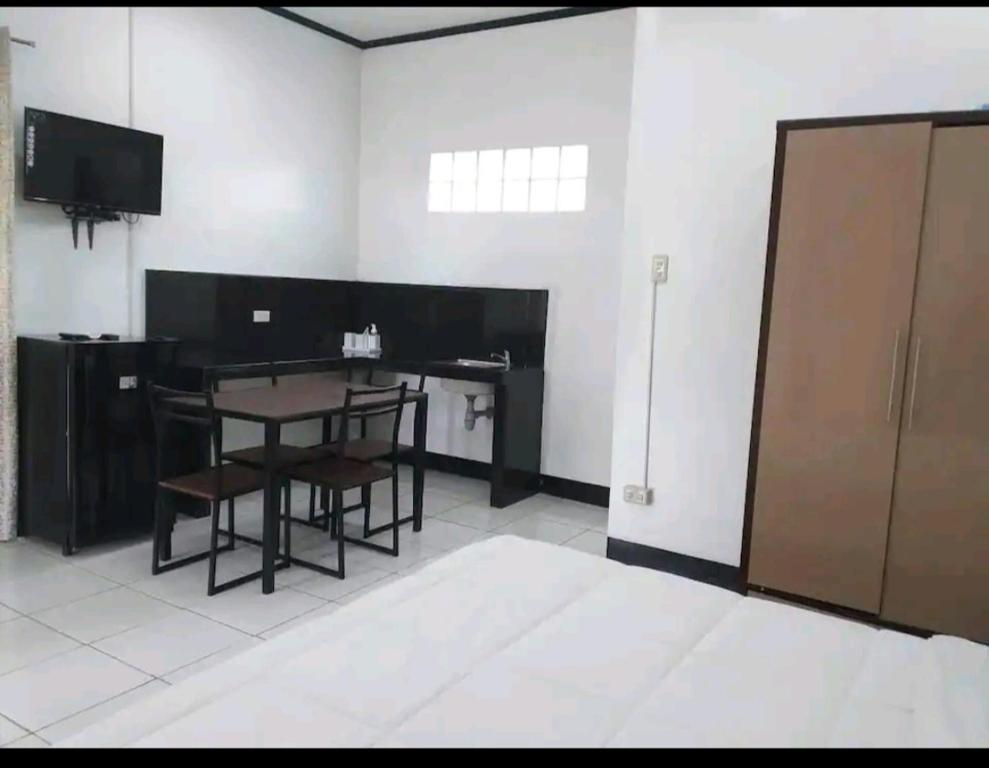um quarto com uma secretária, uma mesa e cadeiras em Ethan's Vacation House (Camiguin) em Mambajao