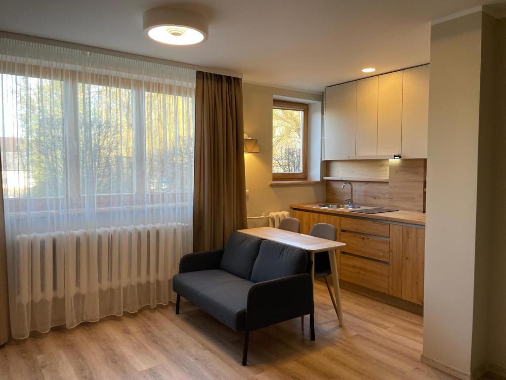 葉爾加瓦的住宿－Centra dzīvoklis，厨房配有桌子、椅子和窗户