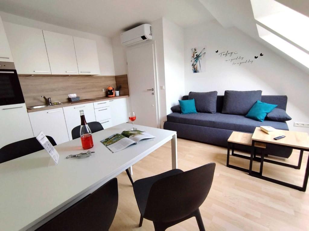 a kitchen and living room with a table and a couch at Ferienzimmer Reinisch in Tattendorf in Tattendorf