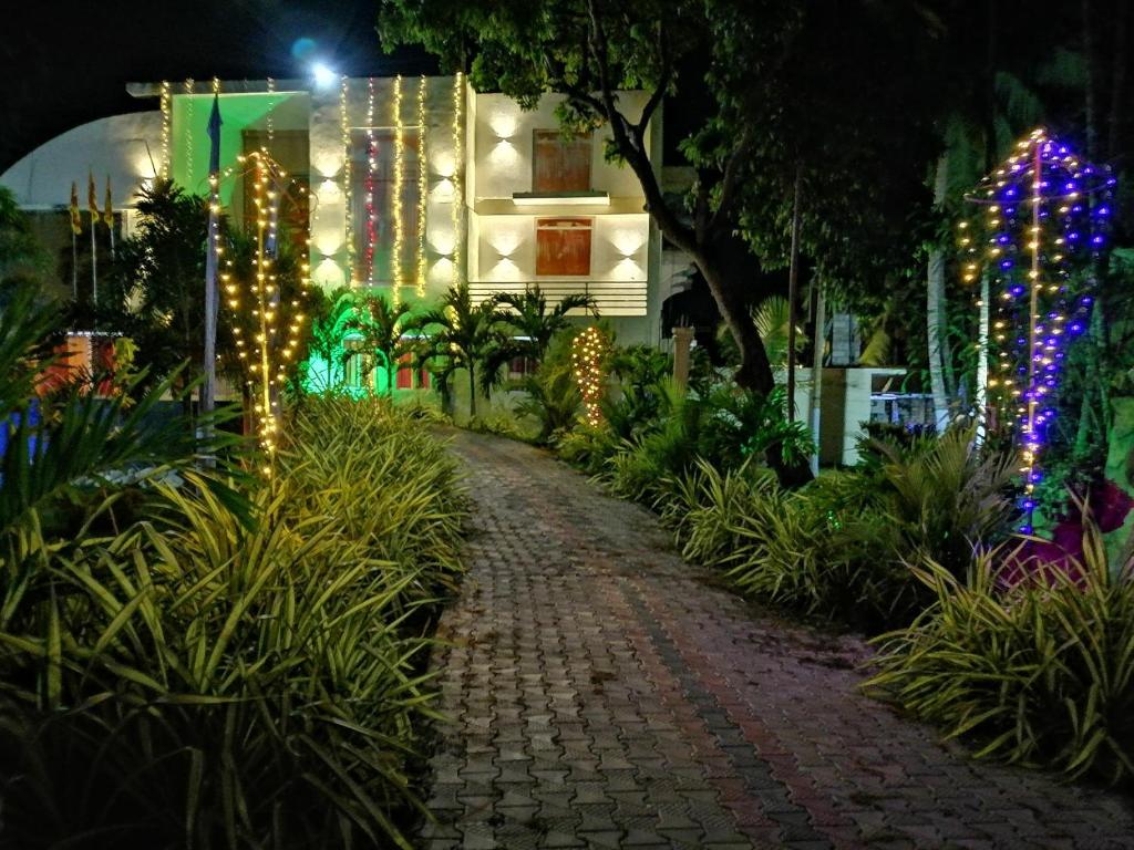 une passerelle avec des lumières de Noël devant un bâtiment dans l'établissement Avanya Hotel And Reception Hall, à Angunakolapelessa