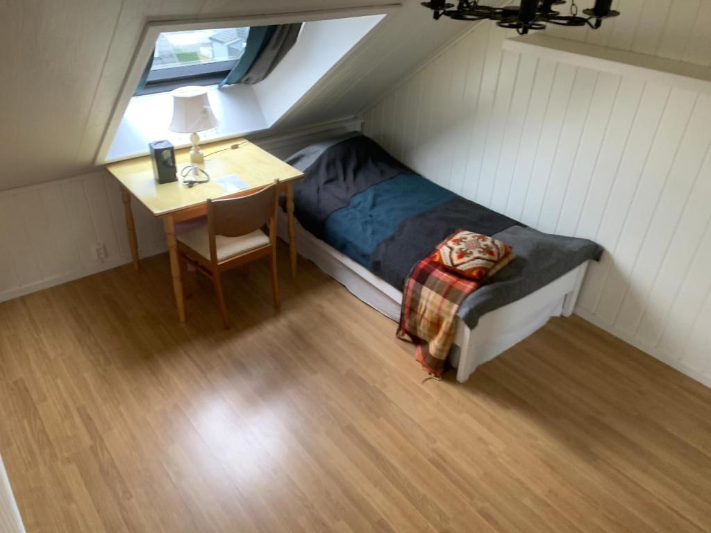 a small bedroom with a bed and a desk at Privat soverom in Moss