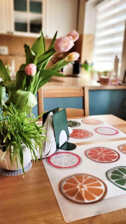 a table with a table cloth with citrus slices on it at Apartament "Przy Jeziorku" in Kętrzyn