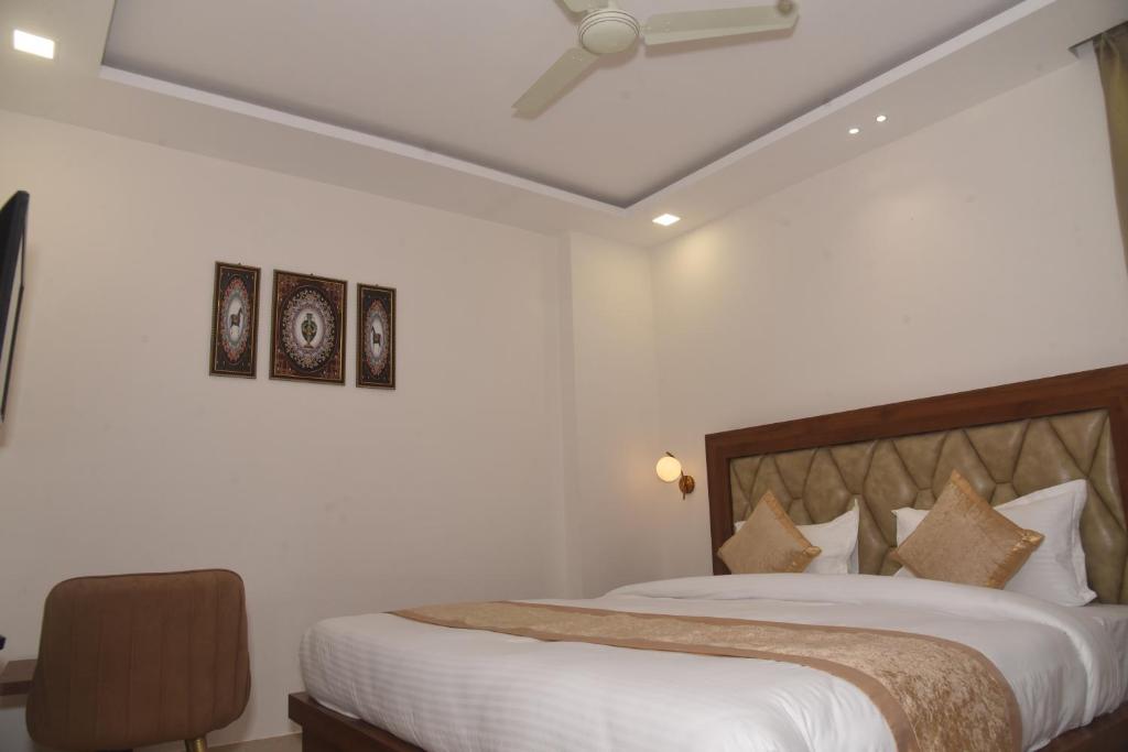 um quarto com uma cama com lençóis brancos e um tecto em HOTEL LAWANG SIGNAGE em Deoghar