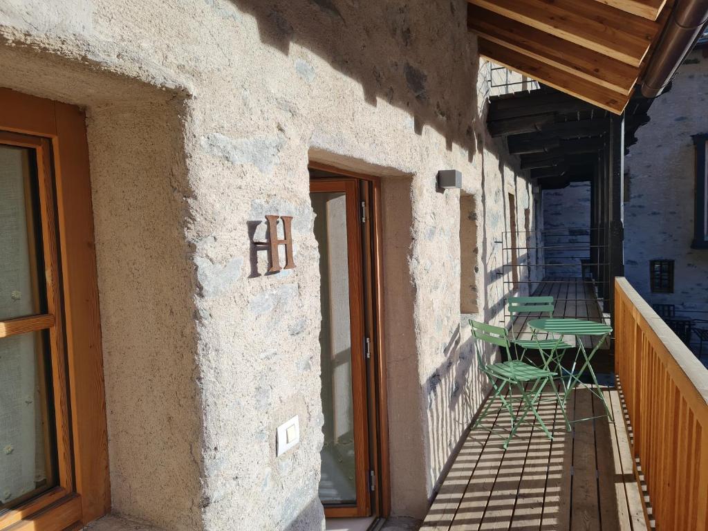 a patio with a table and chairs on the side of a building at La corte Antey Maison De Emilie in Antey-Saint-André