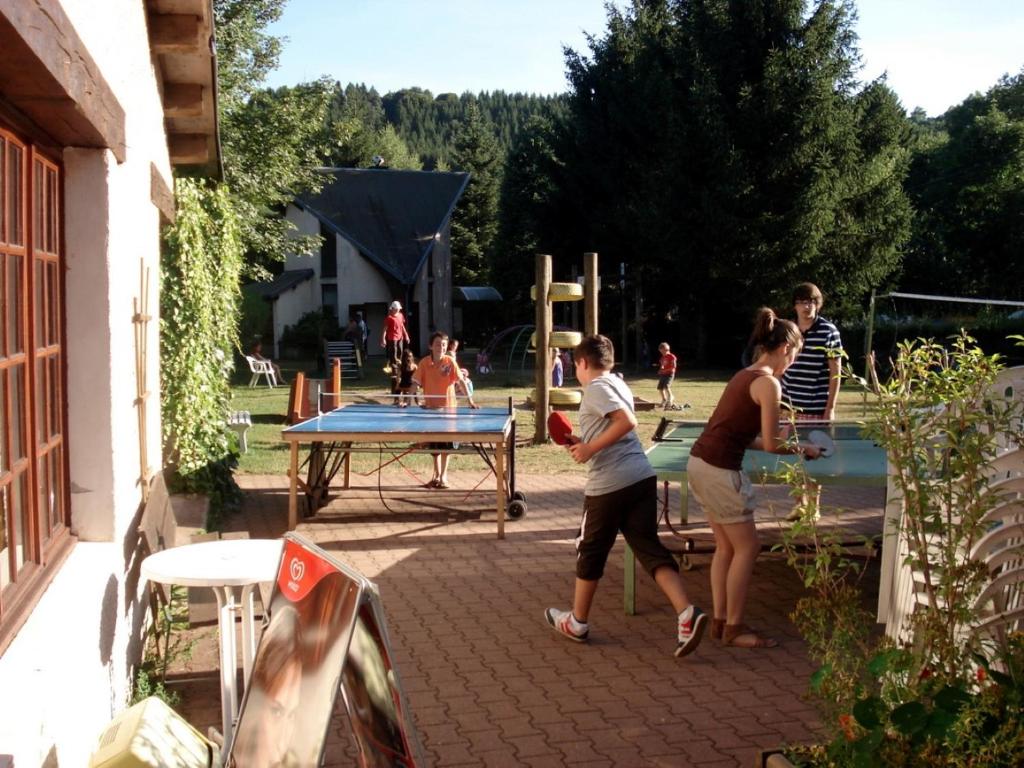 a group of people playing a game of ping pong at Camping la Vallée in La Tour-dʼAuvergne