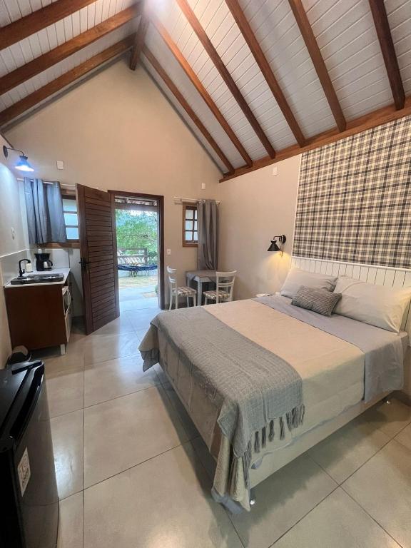 Chalé Rosa Serena في إيمبيتوبا: غرفة نوم بسرير كبير ومطبخ