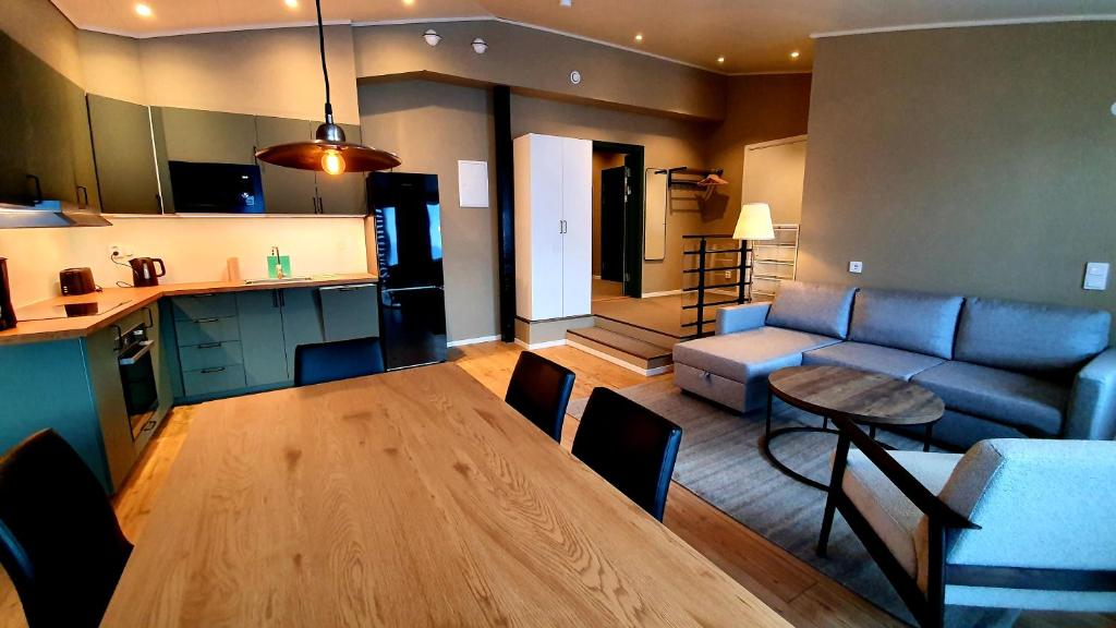 Katterjåkk Apartments في Riksgränsen: مطبخ وغرفة معيشة مع طاولة وأريكة