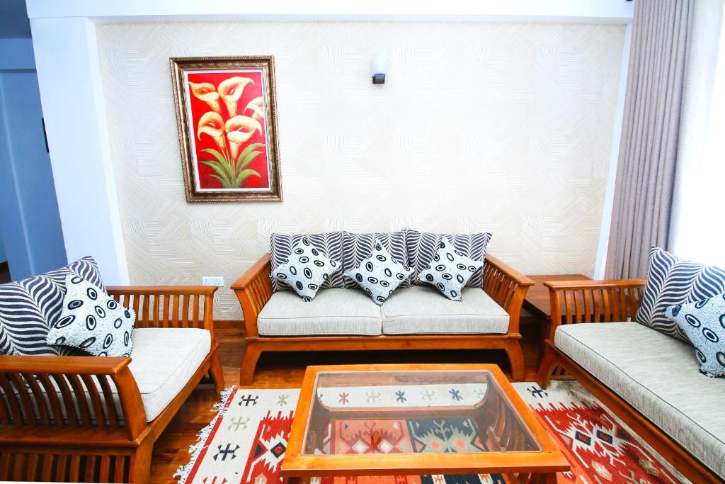 a living room with two couches and a table at Nelma's Cosy in Nuwara Eliya