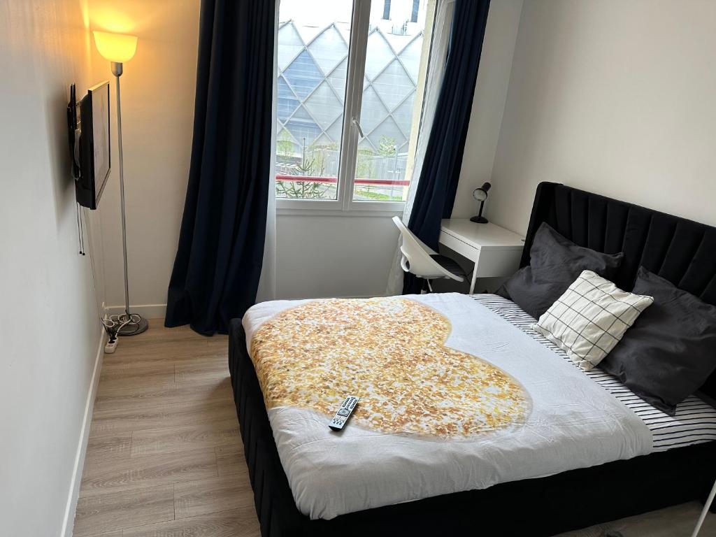 - une chambre avec un lit doté d'une télécommande dans l'établissement Chambre meublée métro 7 La Courneuve 2, à La Courneuve