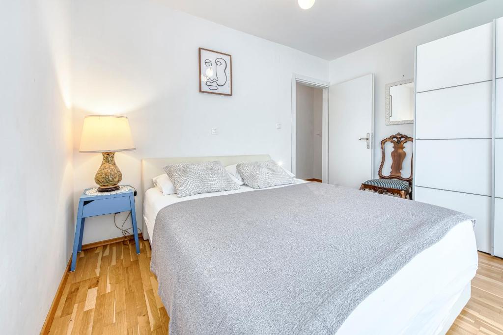 - une chambre blanche avec un grand lit et une lampe dans l'établissement City center Apartments Niva, à Dubrovnik