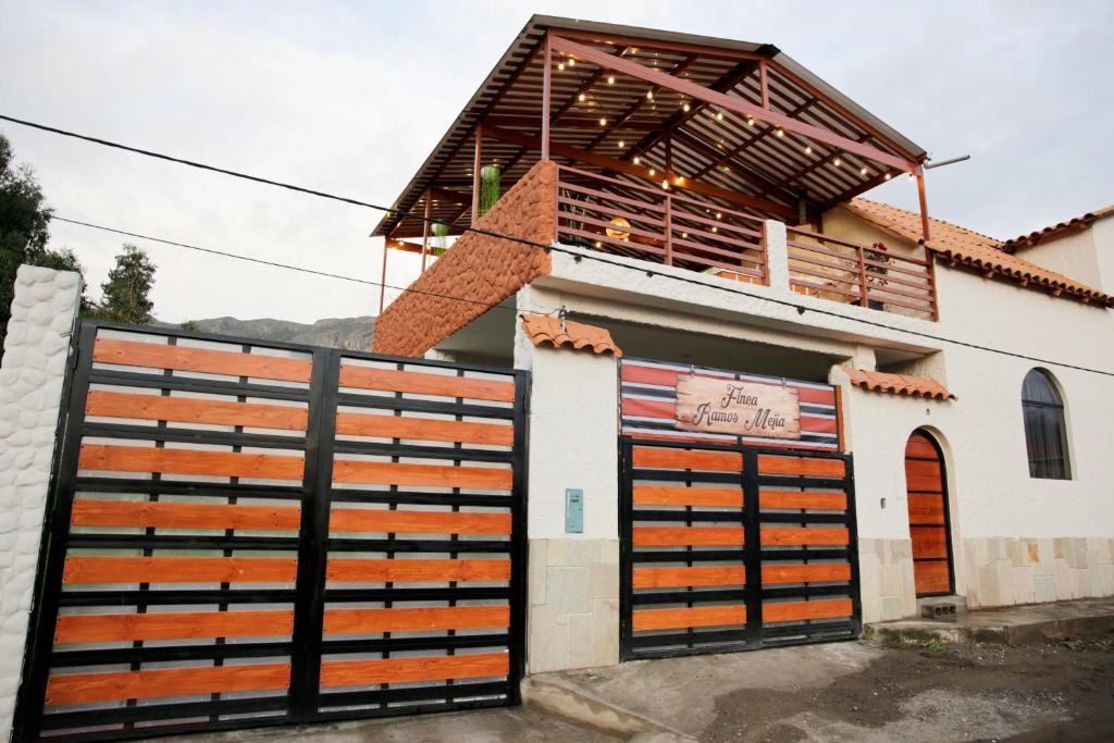 a building with two garage doors and a fence at Finca Ramos Mejia in Coporaque