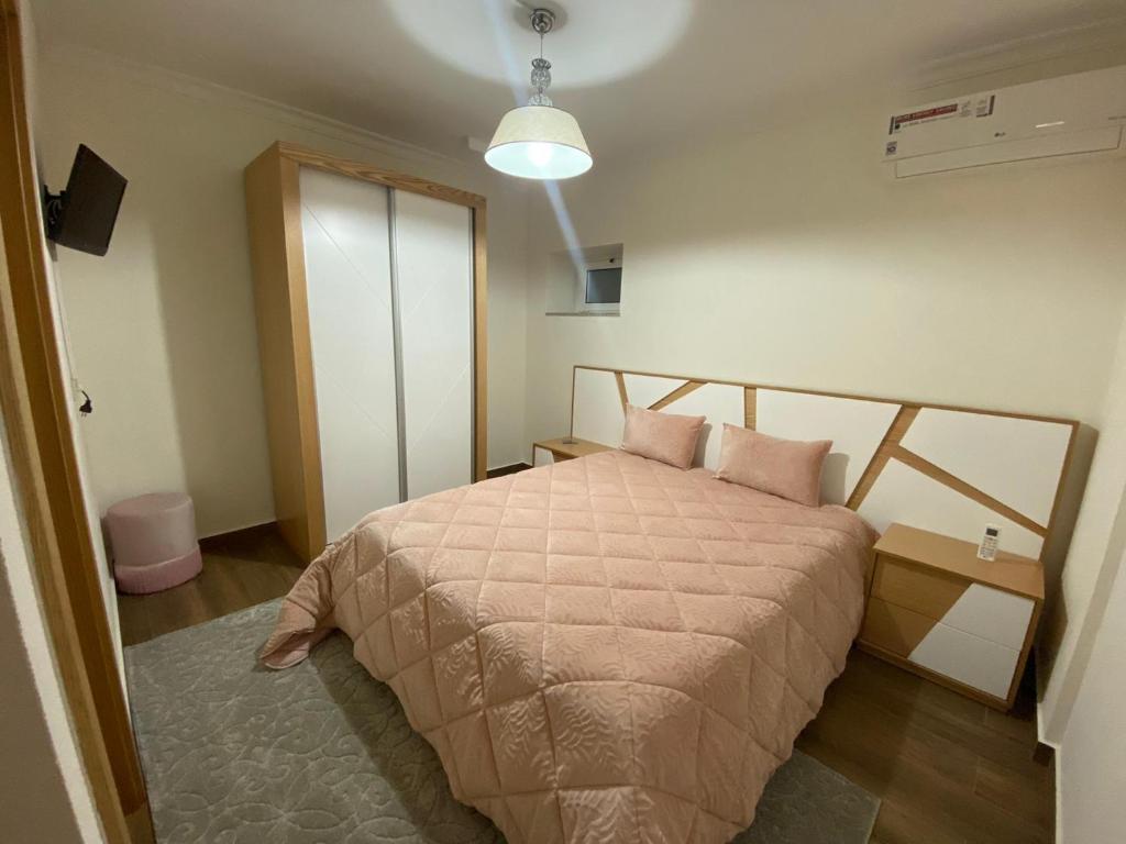 a bedroom with a bed with pink pillows at CoraçãoD´Ouro in Torre de Moncorvo