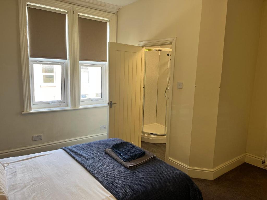 a bedroom with a bed and a walk in shower at Rose House in Derby