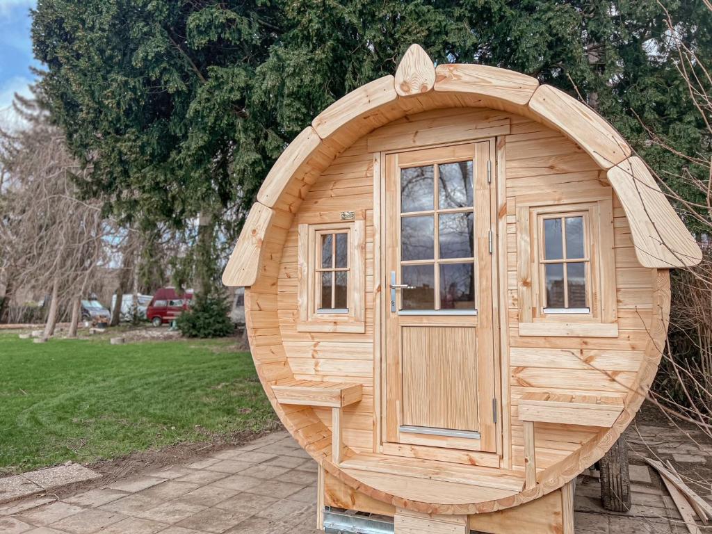 a wooden hobbit house with a window in a yard at Das Wiesenhaus Wohnen im Schlaffass in Cologne