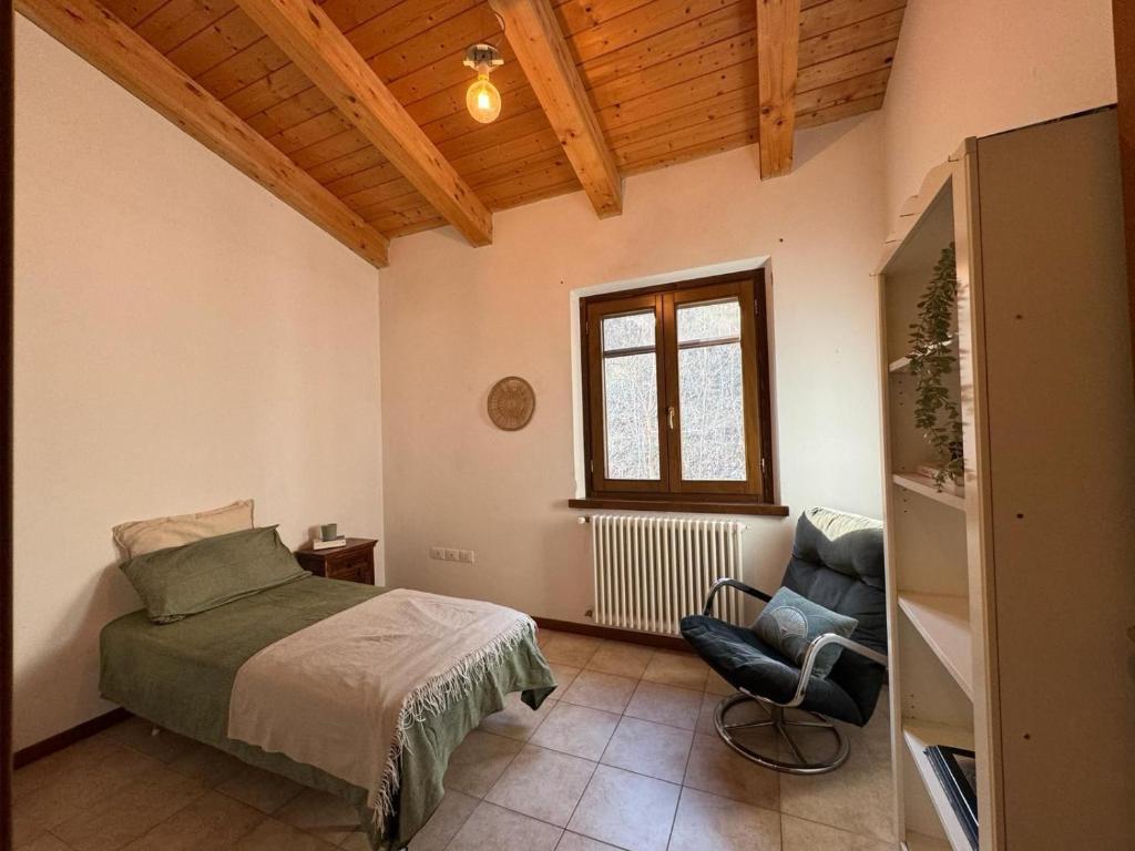 1 dormitorio con 1 cama y 1 silla en una habitación en Appartamento Matteo e Daniela, en San Leo