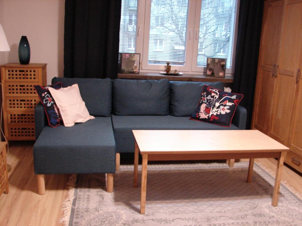 un soggiorno con divano blu e tavolino da caffè di Sowinski Apartament a Lublino