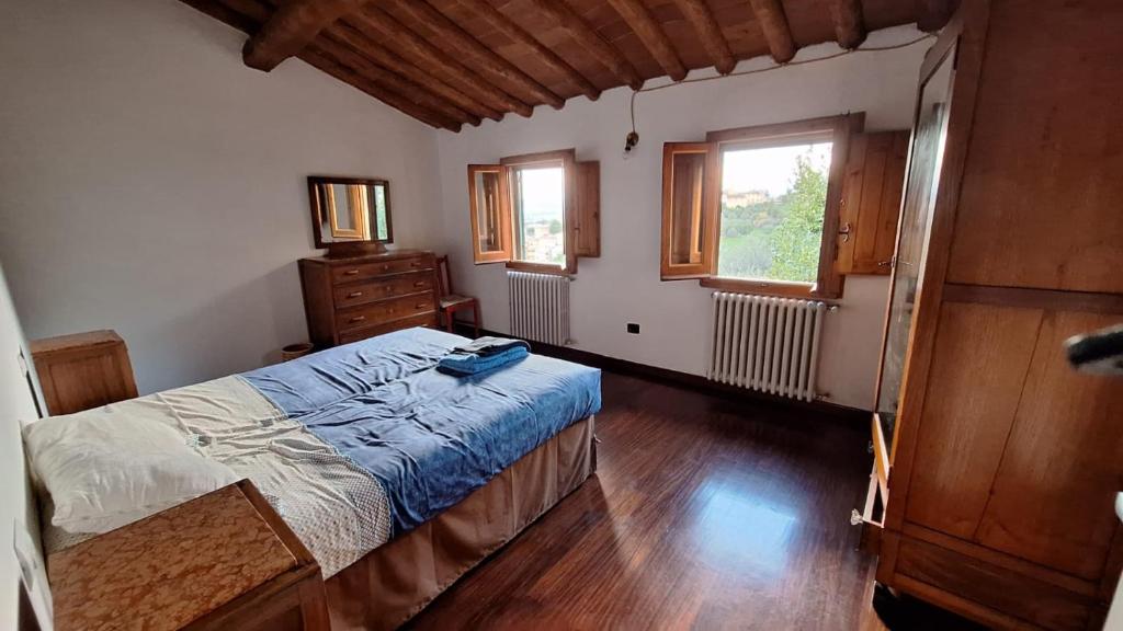 ein Schlafzimmer mit einem Bett, einer Kommode und zwei Fenstern in der Unterkunft Appartamento con vista su Firenze in Lastra a Signa