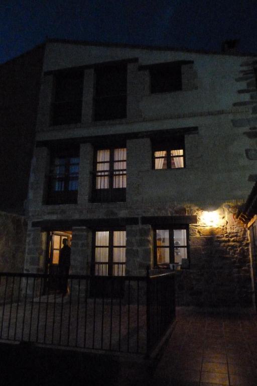 un bâtiment la nuit avec des lumières dans les fenêtres dans l'établissement El Farolillo de Piedra, à Montejo de Tiermes
