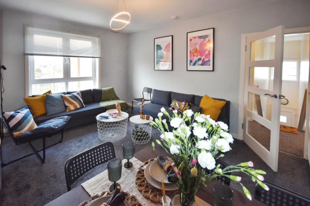 sala de estar con sofá y mesa con flores en Glasgow Modern style home , separate entrance, en Knightswood