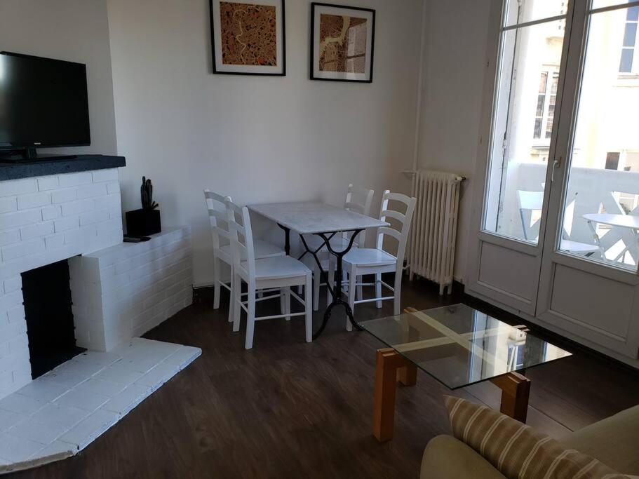 - un salon avec une cheminée, une table et des chaises dans l'établissement Bel Appartement Colombes Centre, à Colombes