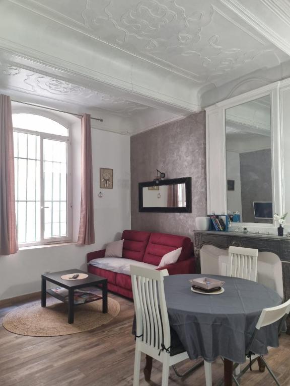 un salon avec une table et un canapé rouge dans l'établissement Studio le RED SOFA, cœur de ville, à La Ciotat