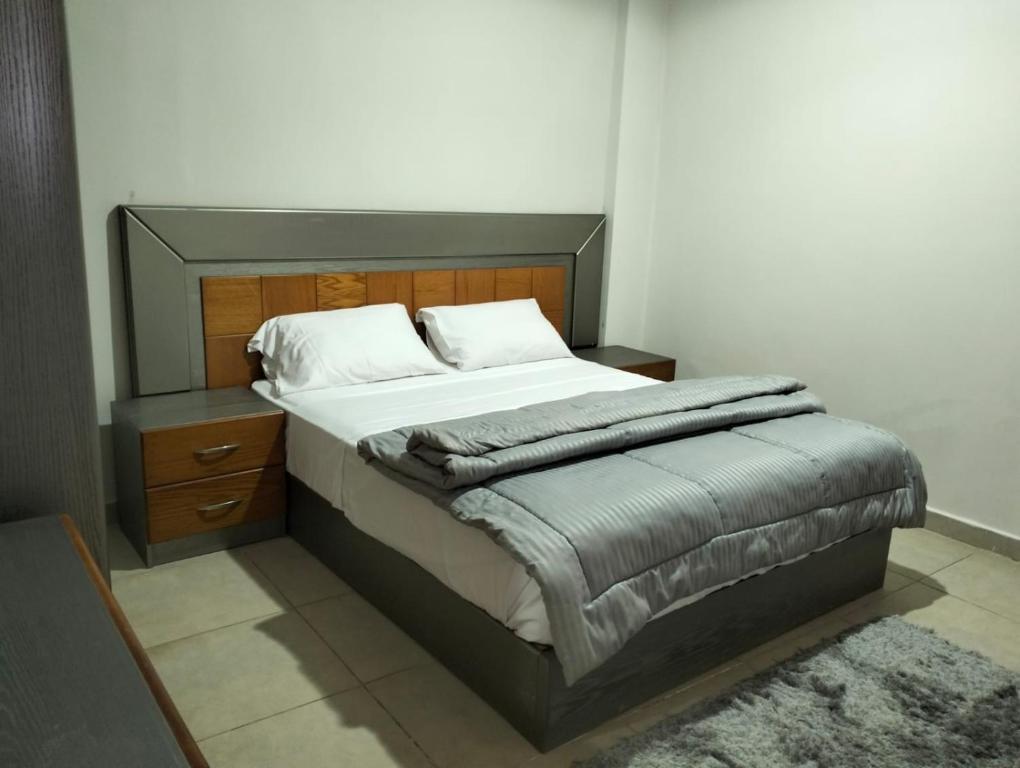 Schlafzimmer mit einem großen Bett mit einem Kopfteil aus Holz in der Unterkunft Nozha Beach - Ras Sudr in Ras Sudr