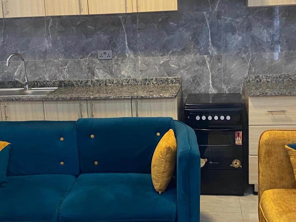 a blue couch in a kitchen with a stove at The Pyramid Apart in Kigali