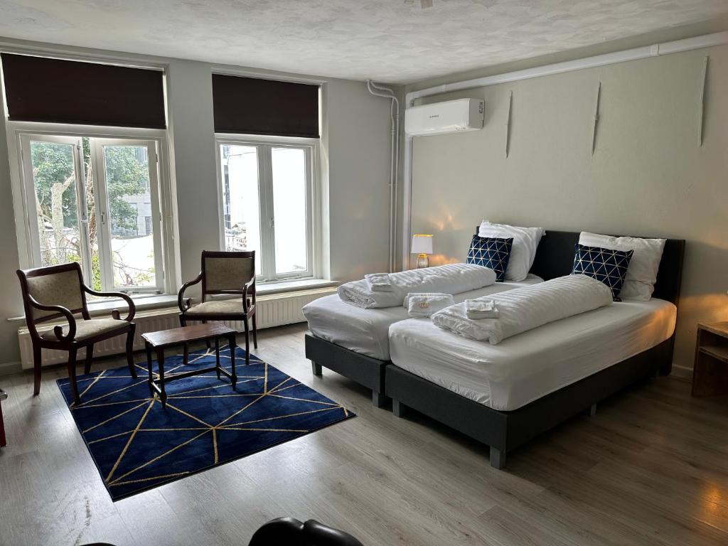 奈梅亨的住宿－De Bronzen Koets，一间卧室配有一张床、一张沙发和两把椅子
