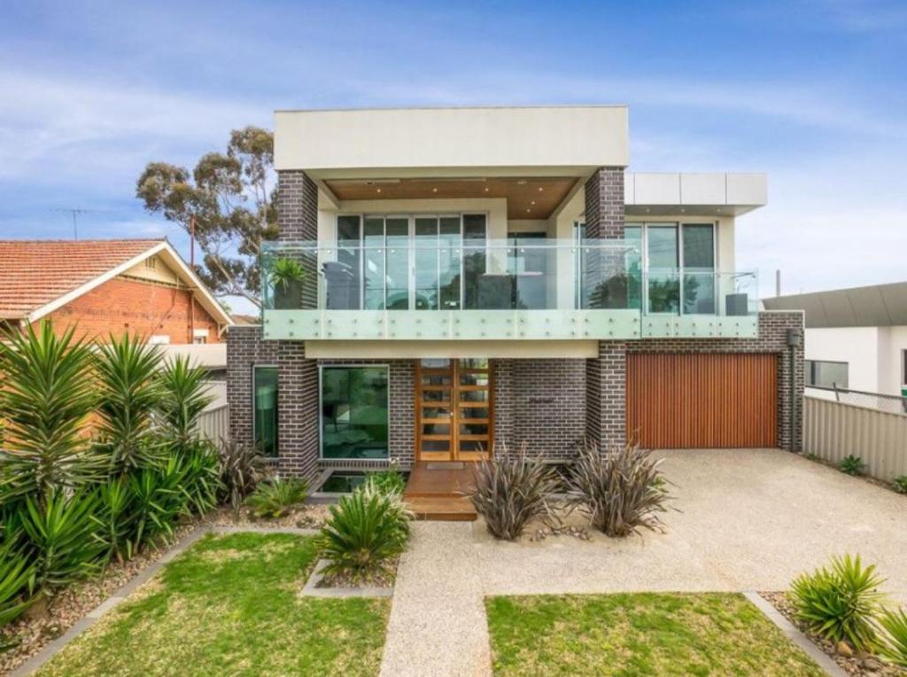 a house with a glass facade with a driveway at Geelong Luxury Beach K Villa in North Shore