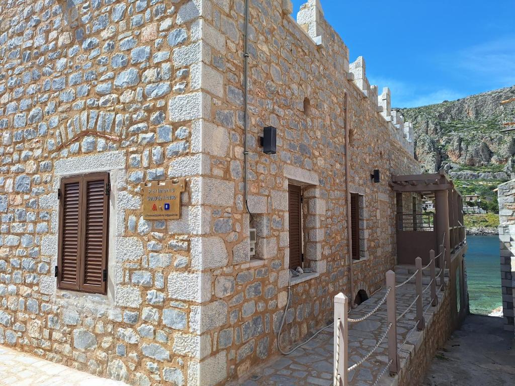 a stone building with a stone wall with a window at Perimenis Seaside House in Gerolimenas