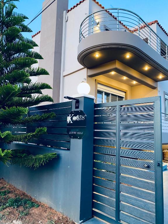 a house with a blue gate and a balcony at Keskos Luxury Villa in Artemida