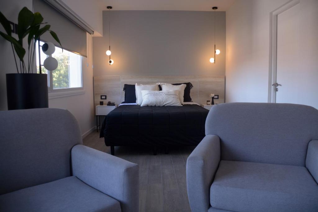 1 dormitorio con 1 cama y 2 sillas en HotelN26 en Mar del Plata