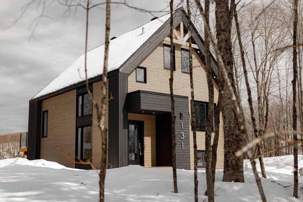 una casa con un tetto innevato nella neve di Le Chamonix/Mountain view/Golf course/Activities! a Saint-Faustin