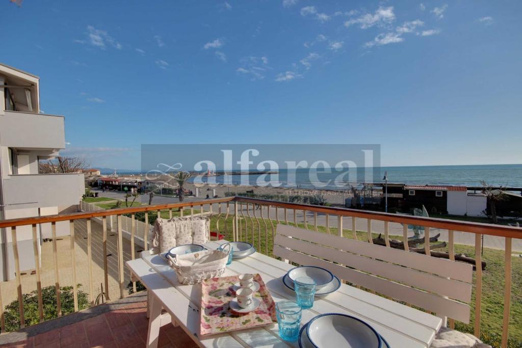 een balkon met uitzicht op het strand bij Elba in Castiglione della Pescaia